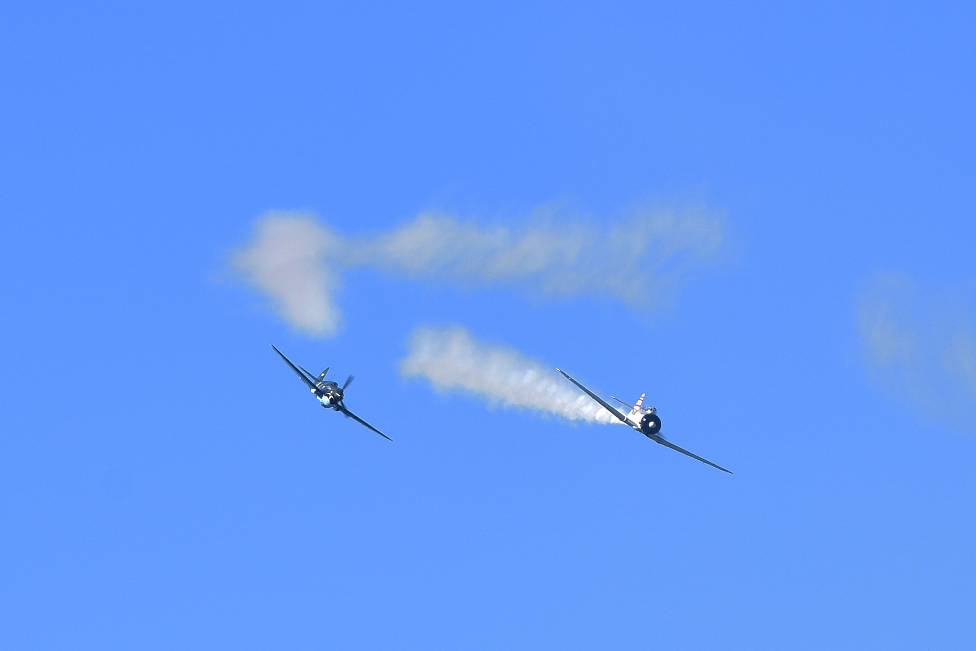 2 planes simulated dogfighting with blue sky behind them