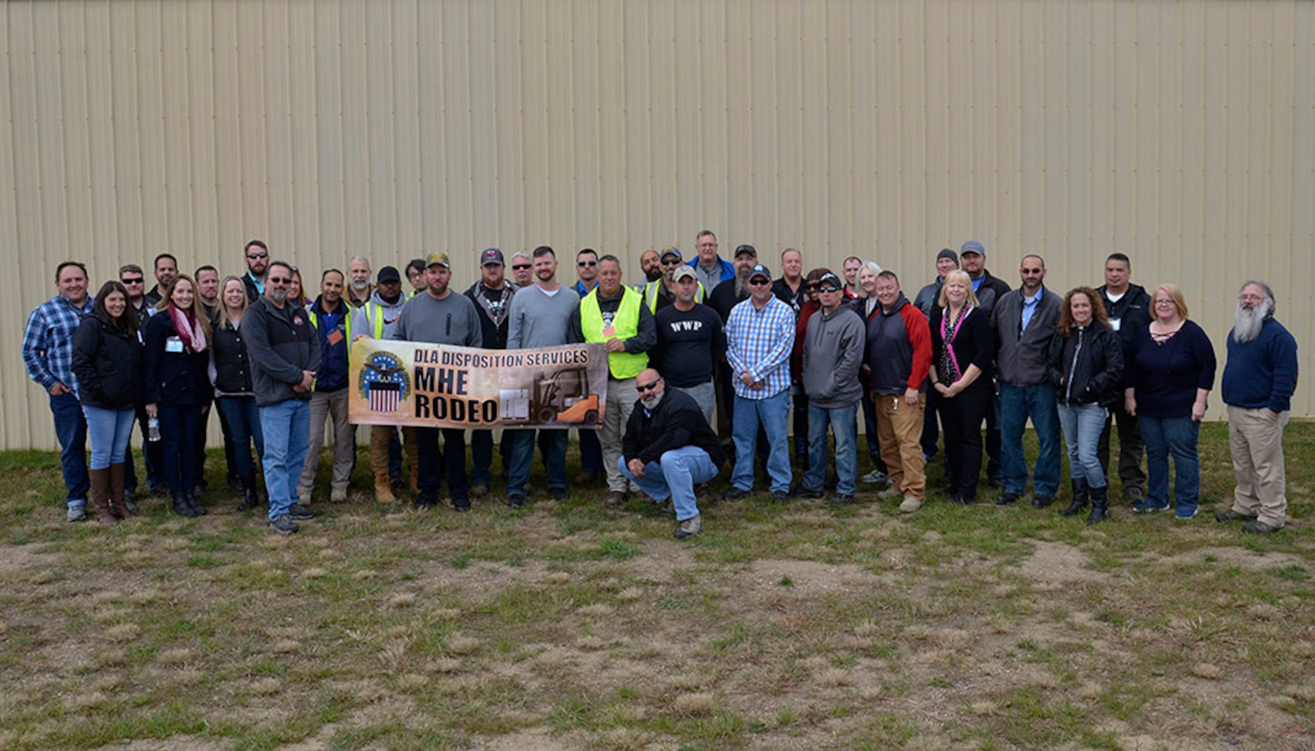 MHE Rodeo competitors, judges and support volunteers pose at the Battle Creek Air National Guard Base in Michigan where the inaugural competition pitted 13 of the agency’s best fork truck drivers from around the globe Oct. 23-25.