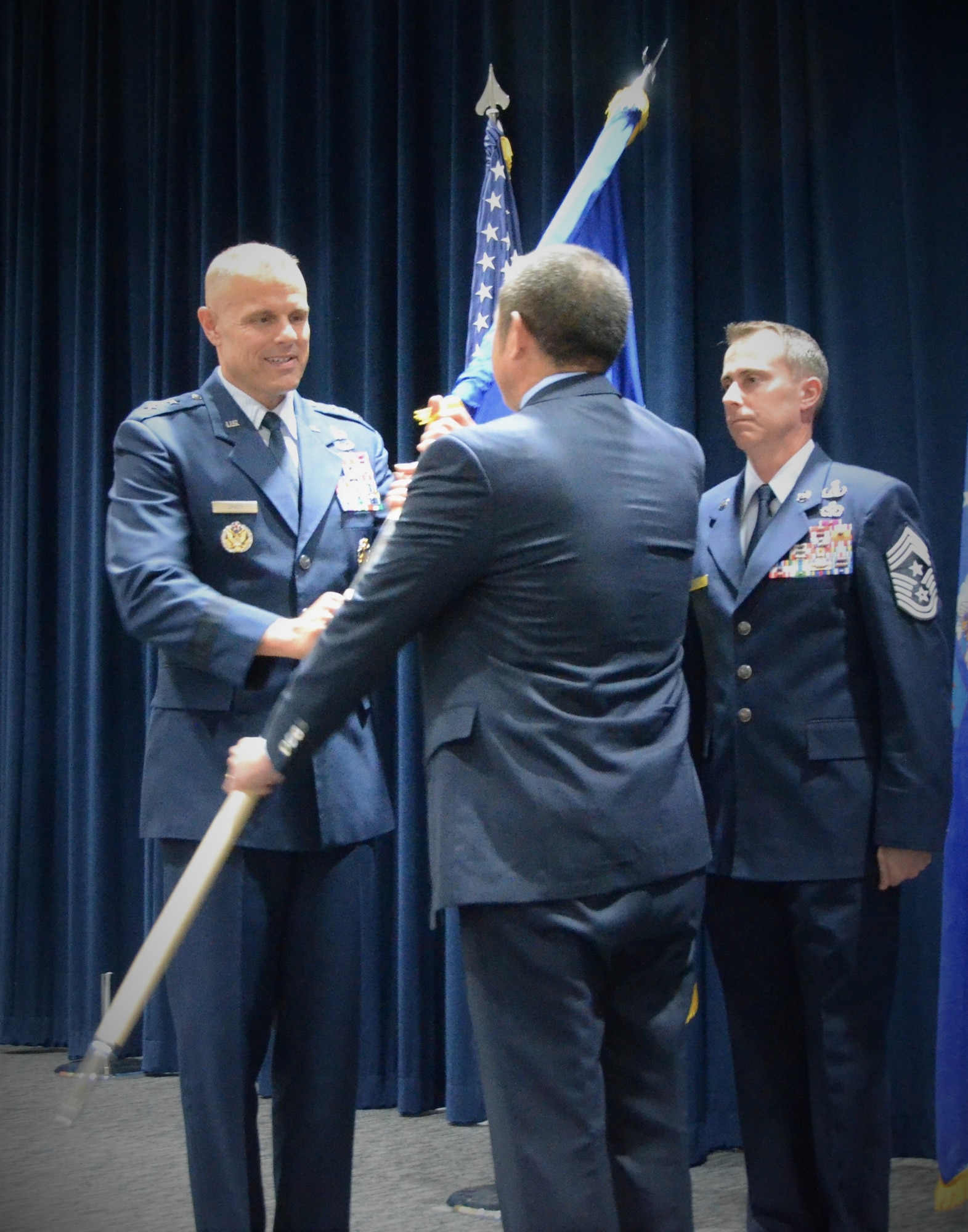 Edwin Oshiba relinquishes the Air Force Civil Engineer Center flag to Maj. Gen. Bradley D. Spacy, Commander, Air Force Installation and Mission Support Center during a change of leadership ceremony at Lackland Air Force Base, Texas, Oct. 29, 2018.