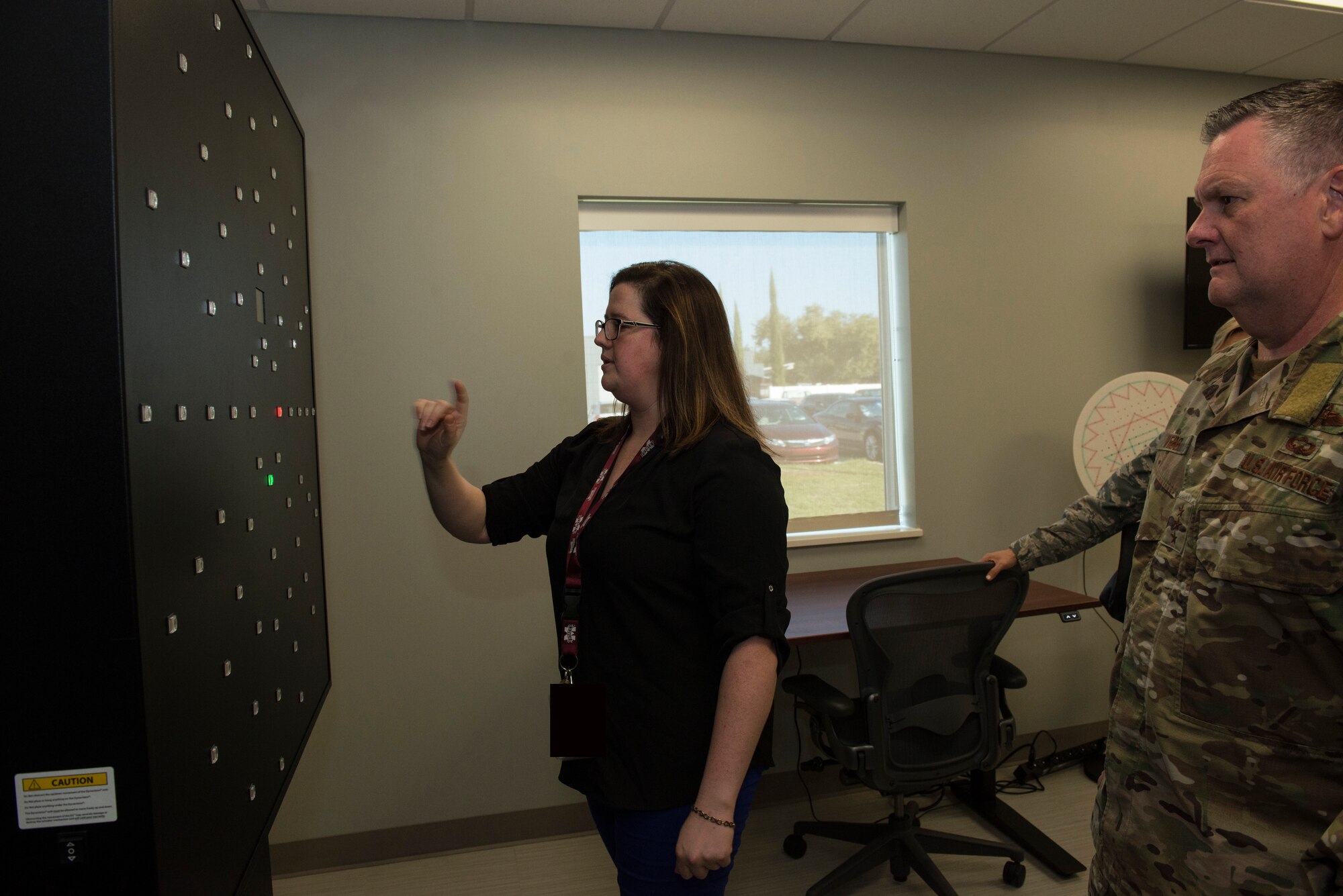 One person showing a piece of equipment to another person.