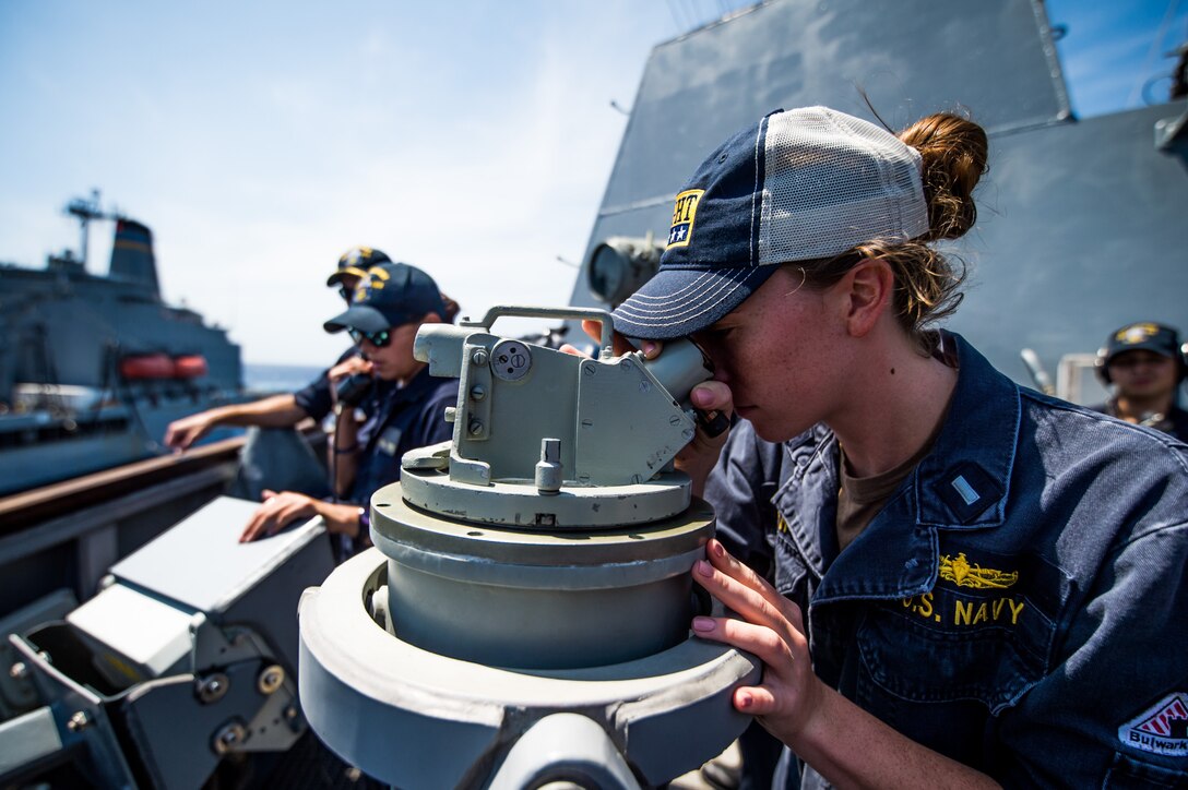 Sailor takes bearing as USS Dewey conducts replenishment-at-sea with USNS Henry J. Kaiser, Pacific Ocean, July 16, 2018 (U.S. Navy/Devin M. Langer)