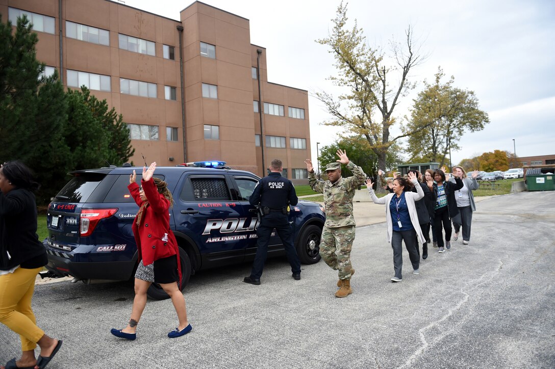 Soldiers and staff from the 85th Support Command and the Defense Contract Management Agency-Chicago evacuate a building during an active shooter training exercise at the command headquarters, Oct. 30, 2018.
