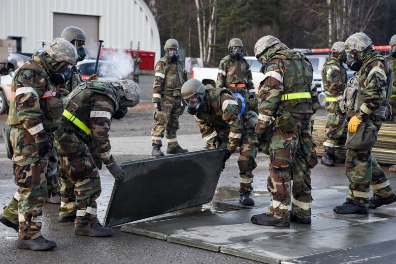 Airmen with the 773d Civil Engineer Squadron repair damage on a flightline after a mock attack during exercise Polar Force 19-1 at Joint Base Elmendorf-Richardson, Alaska, Oct. 24, 2018. Exercise Polar Force showcases unit combat readiness while fighting in chemical, biological, radiological and nuclear defense protective gear.
