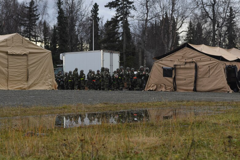 U.S. Airmen line up for breakfast at the 673d Force Support Squadron tent during exercise Polar Force 19-1 at Joint Base Elmendorf-Richardson, Alaska, Oct. 24, 2018. Exercise Polar Force showcases unit combat readiness while fighting in chemical, biological, radiological and nuclear defense protective gear.