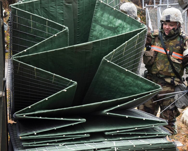 U.S. Air Force Staff Sgt. Jeffrey Carr, 773d Civil Engineer Squadron, picks up a HESCO barrier for construction during exercise Polar Force 19-1 at Joint Base Elmendorf-Richardson, Alaska, Oct. 25, 2018. Sections of the collapsible barrier were linked together and filled with dirt to provide added protection at the entry control point of the exercise.