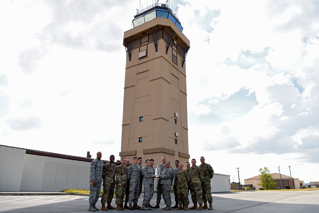 U.S. Airmen with the 51st Operations Support Squadron airfield operations flight pose for a photo with the Airfield Operations Flight Complex of the Year trophy on the flightline at Osan Air Base, Republic of Korea, Oct. 18, 2018. The award was presented to the flight for their exemplary work from Jan. 1, 2017 to Dec. 31, 2017. (U.S. Air Force photo by Senior Airman Kelsey Tucker)