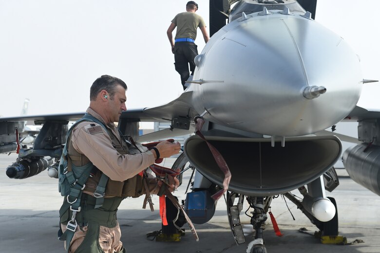 A pilot and crew chief prepare an F-16 Fighting Falcon for take off.