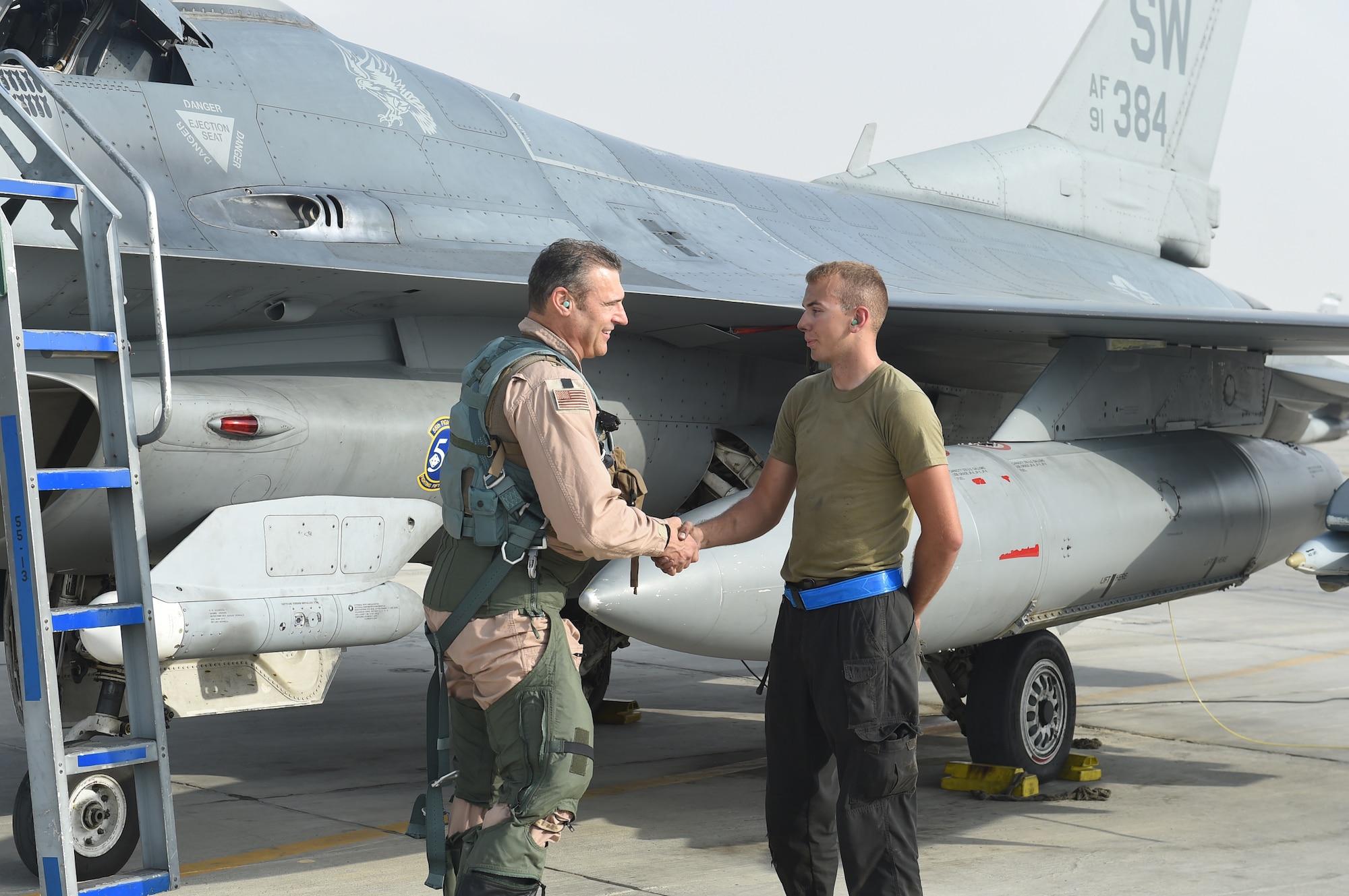 A pilot and crew chief prepare an F-16 Fighting Falcon for take off.
