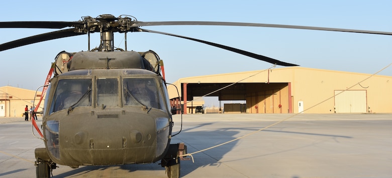 One of the Afghan National Air Force helicopters sits in the foreground of the completed Tango Tech Building A at Kandahar Air Field.