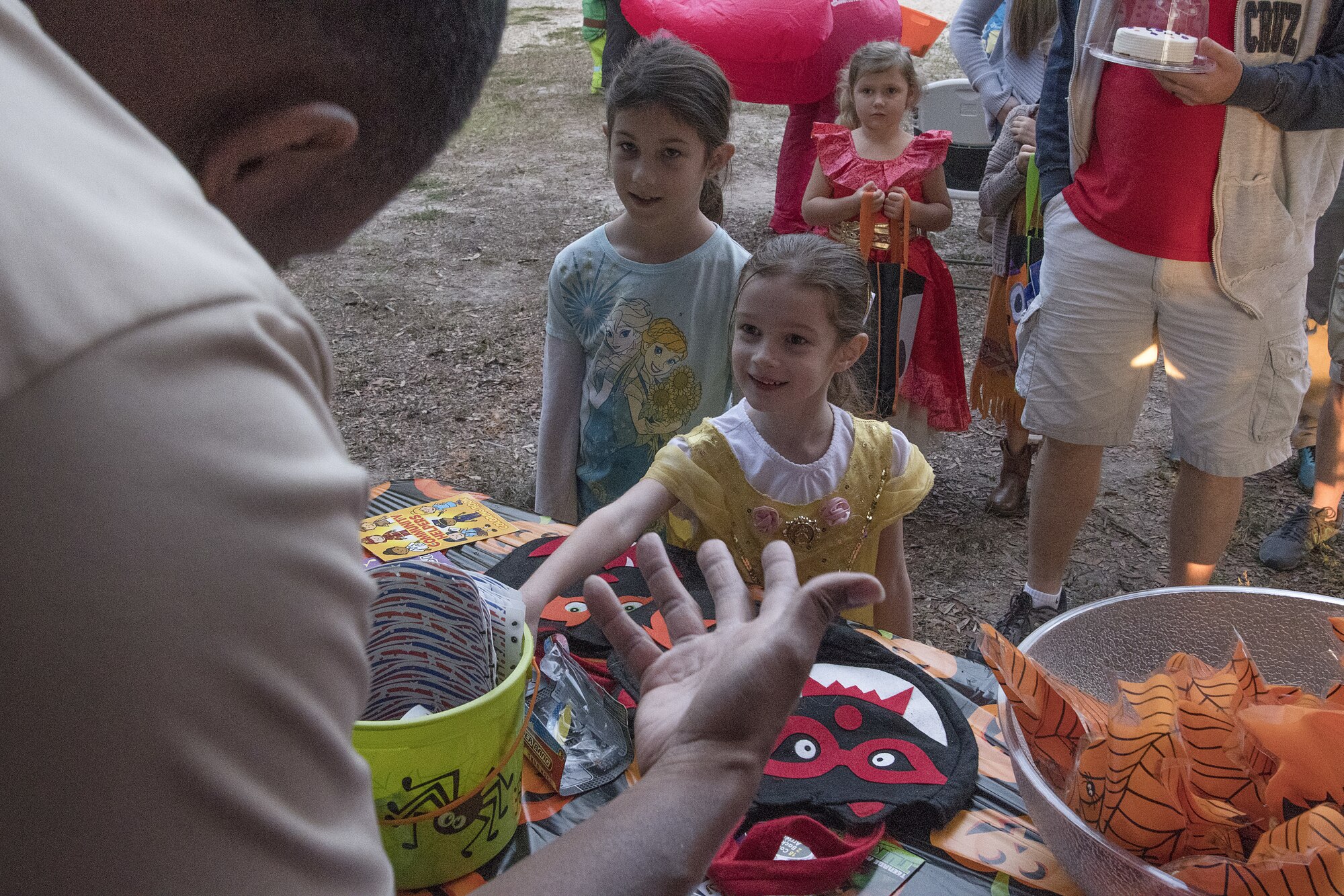 U.S. Air Force Tech. Sgt. Detrick Jack, 81st Force Support Squadron readiness NCO in charge, gives out candy to Della Brasier, daughter of Master Sgt. Sean Brasier, 2nd Air Force military training superintendent, during Ghouls in the Park at Marina Park at Keesler Air Force Base, Mississippi, Oct. 26, 2018. Ghouls in the Park also featured the Boo Bus, a haunted house and various games for children of all ages. (U.S. Air Force photo by Airman 1st Class Suzie Plotnikov)