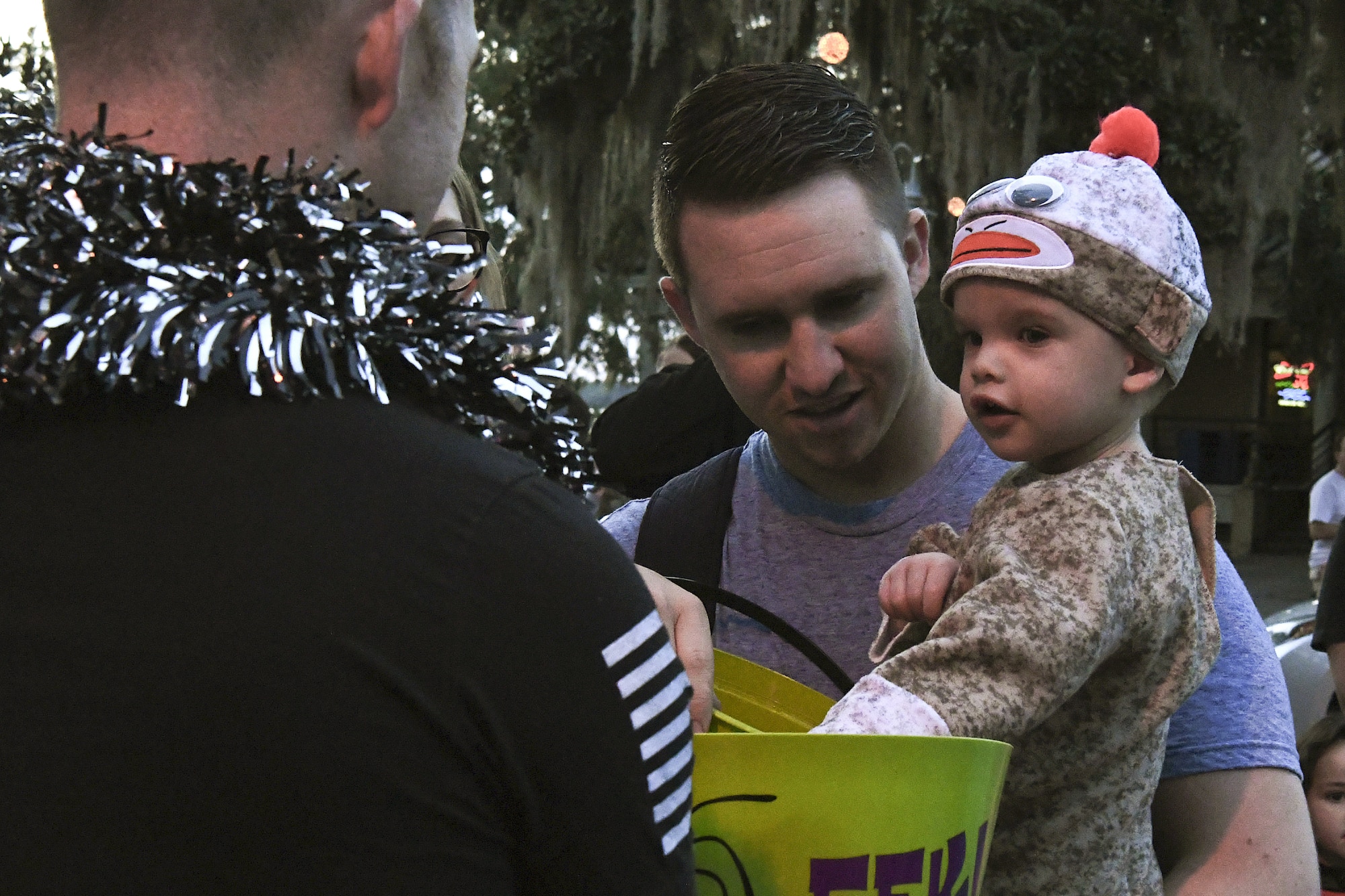 U.S. Air Force Senior Airman Mitchell Graves, 81st Security Forces Squadron patrolman, receives candy with son, Leon, during Ghouls in the Park at Marina Park at Keesler Air Force Base, Mississippi, Oct. 26, 2018. In addition to trick or treating, Ghouls in the Park also featured the Boo Bus, a haunted house and various games for children of all ages. (U.S. Air Force photo by Airman 1st Class Suzie Plotnikov)