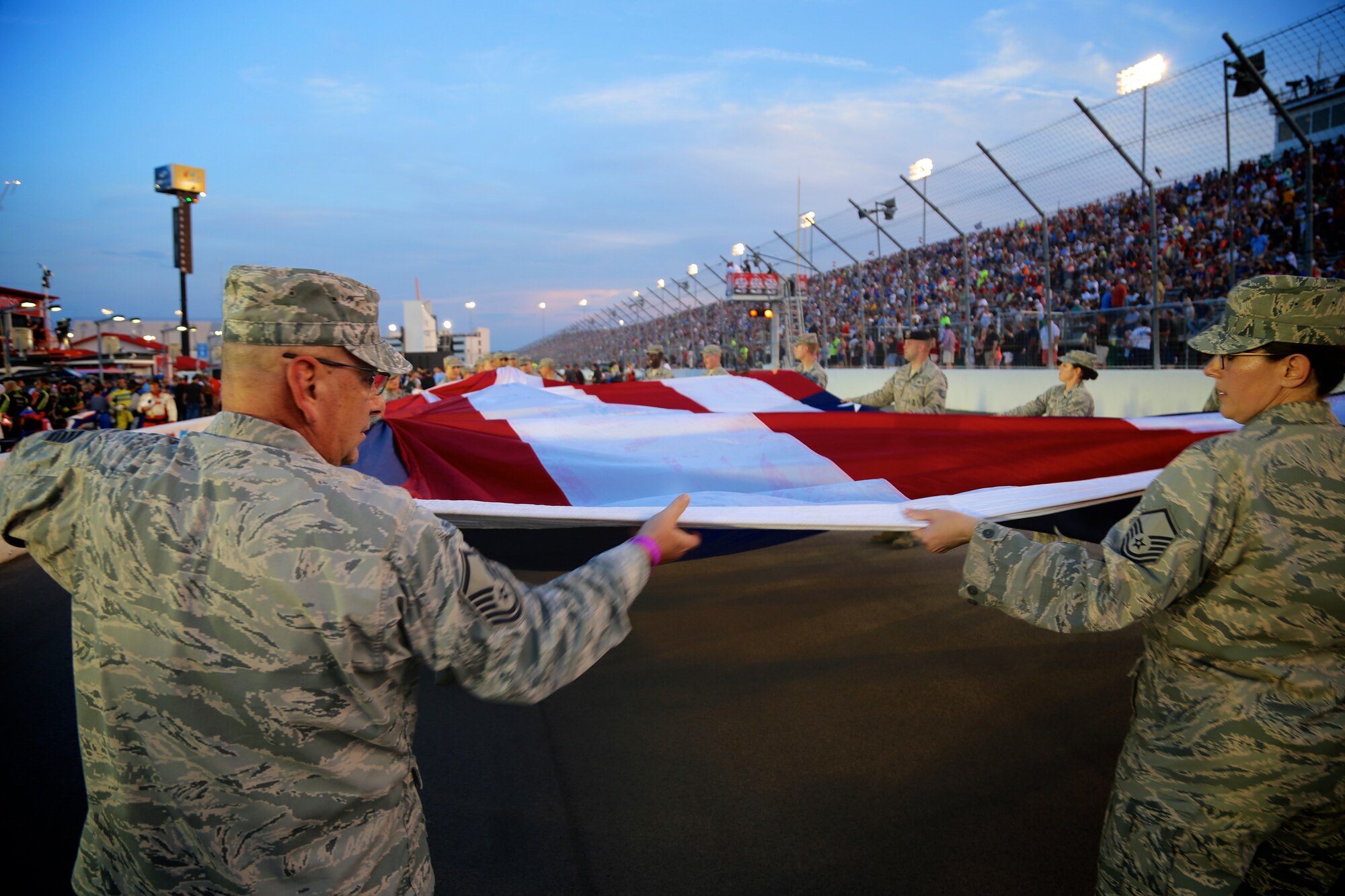 Master Sgt. Gerald Sonnenberg and Master Sgt. Karen Ridge unroll the American flag for the national anthem at Gateway track recently.  As part of the event, 932nd Airlift Wing Maintenance Group commander, Col. Sharon Johnson, was recognized to the crowd on stage with the Indy drivers at the Bommarito Automotive Group 500 Aug. 25, 2018, Gateway Motorsports Park, Madison, Illinois. Johnson was an honored VIP to help kick off the 2nd annual IndyCar race which was won by Will Power, taking the trophy by winning the 248-lap race around the four-turn, 1.25-mile Gateway Motorsports Park oval-paved track in Madison, Illinois.  Power accomplished the win in his #12 Chevrolet by 1.3117 seconds over second place finisher Alexander Rossi.  The 932nd Airlift Wing was represented by maintenance, medical, public affairs staff and operations personnel.  (U.S. Air Force photo by Lt. Col. Stan Paregien