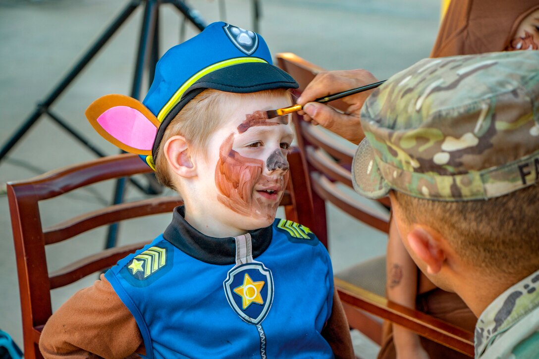 A soldier paints a child's face .