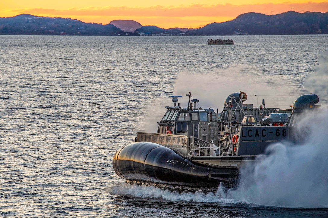 A landing ship speed along the waters of a harbor.