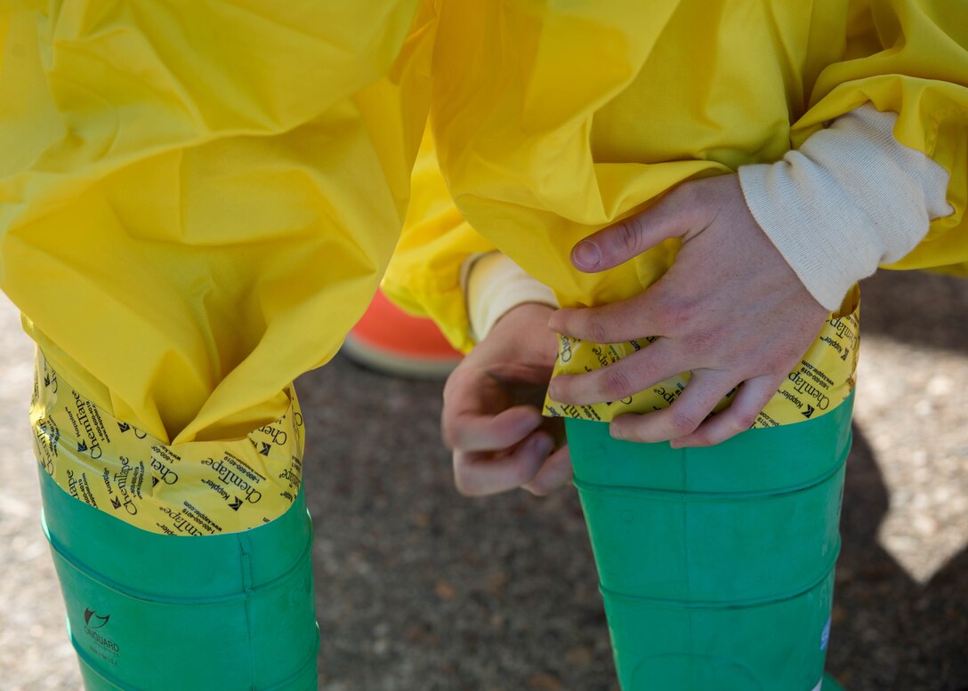 U.S. Air Force Airmen assigned to the 633rd Civil Engineer Squadron and the 633rd Aerospace Medicine Squadron help each other seal their suits during a joint radiological response training at Joint Base Langley-Eustis, Virginia, Oct. 3, 2018.