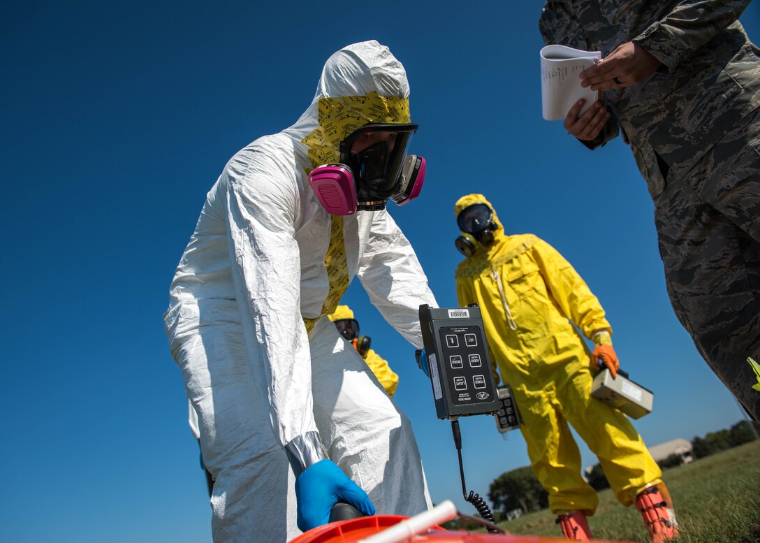 U.S. Air Force Airmen assigned to the 633rd Civil Engineer Squadron and the 633rd Aerospace Medicine Squadron inspect a bucket for radiation exposure during a joint radiological response training at Joint Base Langley-Eustis, Virginia, Oct. 3, 2018.