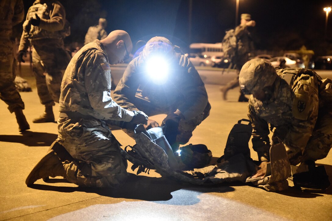 U.S. Army Soldiers from the 331st Transportation Company, 11th Transportation Battalion, 7th Transportation Brigade (Expeditionary), inspect each other's field gear to confirm operability or identify deficiencies during an emergency deployment readiness exercise at Joint Base Langley-Eustis, Virginia, Oct. 22, 2018.