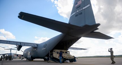 Air Force Staff Sgt. Michael Harrison, 502nd Logistics Readiness Squadron, passenger service NCOIC, directs a HMMMV from the back of a C-130 Hercules in support of Operation Faithful Patriot at Joint Base San Antonio-Lackland AFB Oct. 29. The C-17 Globemaster III and C-130 aircrews provided strategic airlift to Headquarters Company, 89th Military Police Brigade, who are deploying Soldiers, equipment and resources to assist the Department of Homeland Security along the southwest border.