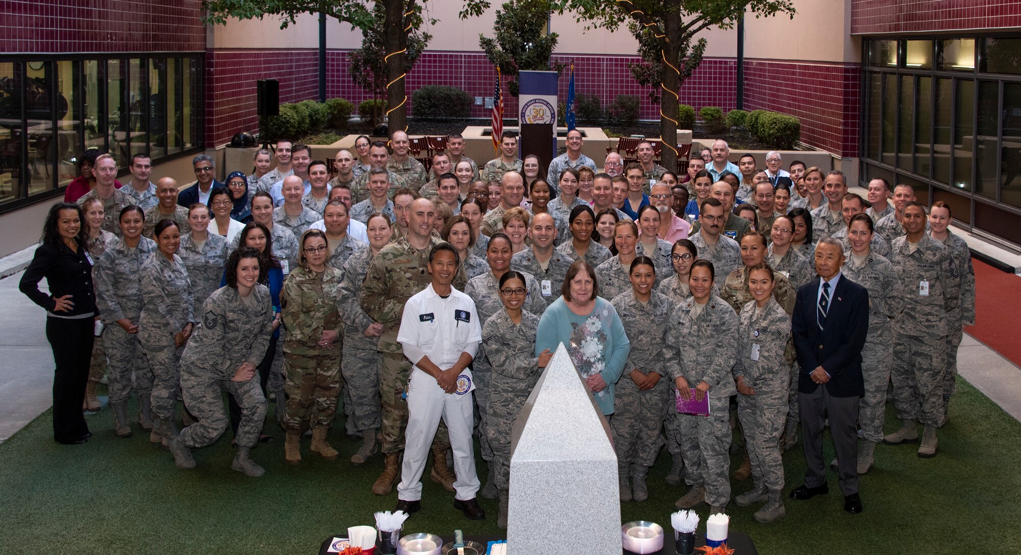 Medical personnel gather together for a group photo, Oct. 30, 2018, Travis Air Force Base, Calif.  David Grant U.S. Air Force Medical Center celebrated its 30th Anniversary with cake and testimonials from past and present patients. DGMC is the Air Force's flagship treatment facility, in the United States, providing a full spectrum of health care and patient-centered treatment to a prime service area throughout eight western states. (U.S. Air Force Photo by Heide Couch)