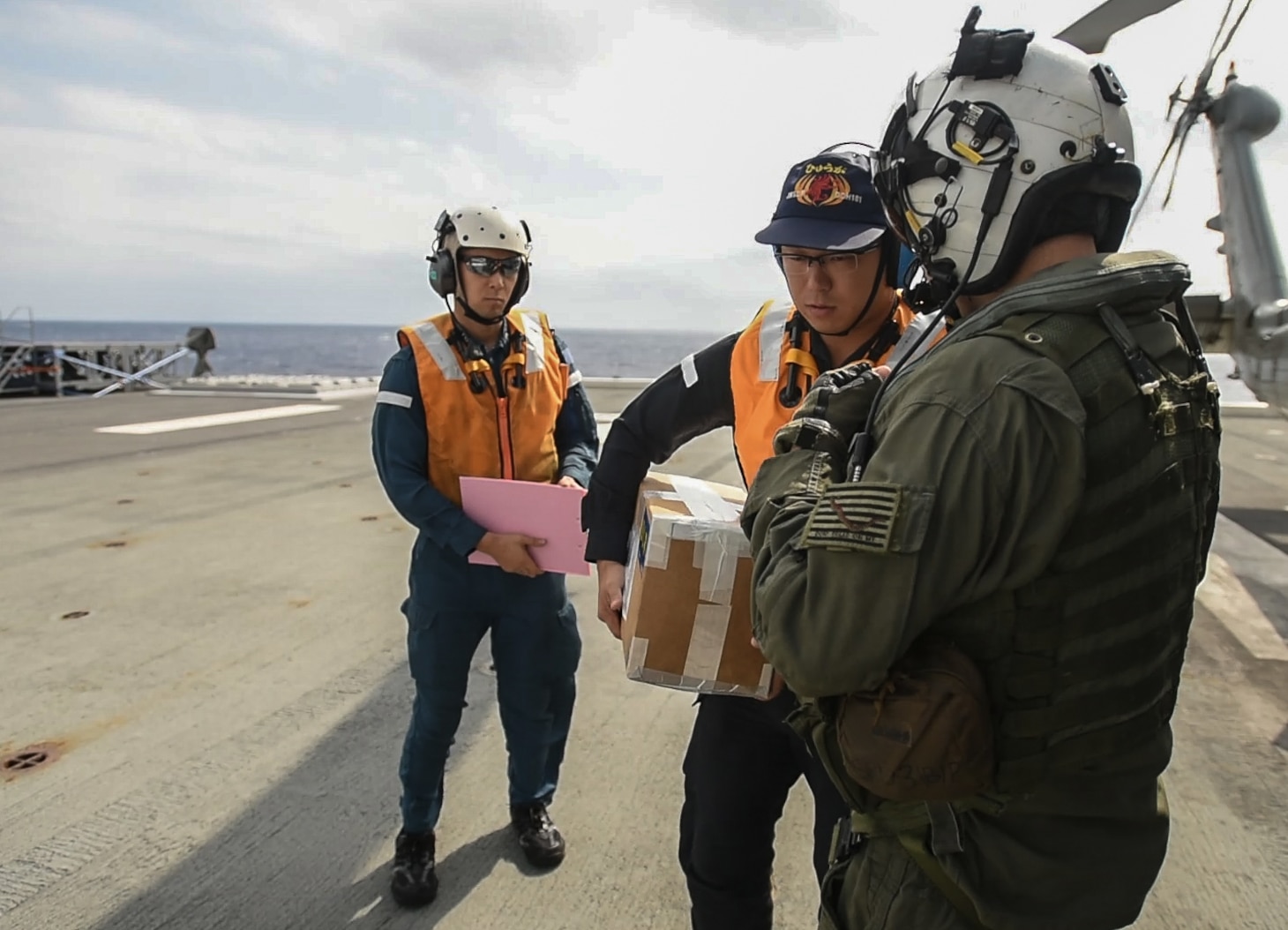 PHILIPPINE SEA (Oct. 31, 2018) Naval Aircrewman (Helicopter) 2nd Class Ryan Quinn, assigned to Helicopter Maritime Strike Squadron (HSM) 77, delivers a repair part to the Japan Maritime Self-Defense Force ship JS Huyuga (DDH-181) for an Acquisition and Cross Servicing Agreement Logistics Exchange during Keen Sword 19. Keen Sword 19 is a joint, bilateral field-training exercise involving U.S. military and Japan Maritime Self-Defense Force personnel, designed to increase combat readiness and interoperability of the Japan-U.S. alliance.