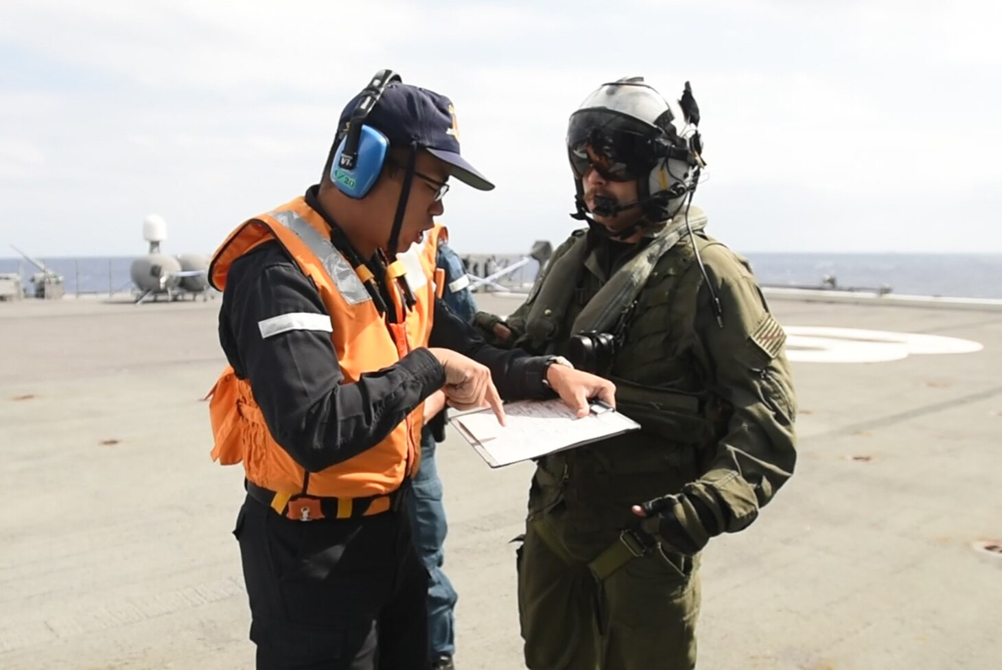 PHILIPPINE SEA (Oct. 31, 2018) Naval Aircrewman (Helicopter) 2nd Class Ryan Quinn, assigned to Helicopter Maritime Strike Squadron (HSM) 77, and a member of the Japan Maritime Self-Defense Force ship JS Huyuga (DDH-181) discuss an Acquisition and Cross Servicing Agreement Logistics Exchange during Keen Sword 19. Keen Sword 19 is a joint, bilateral field-training exercise involving U.S. military and Japan Maritime Self-Defense Force personnel, designed to increase combat readiness and interoperability of the Japan-U.S. alliance.