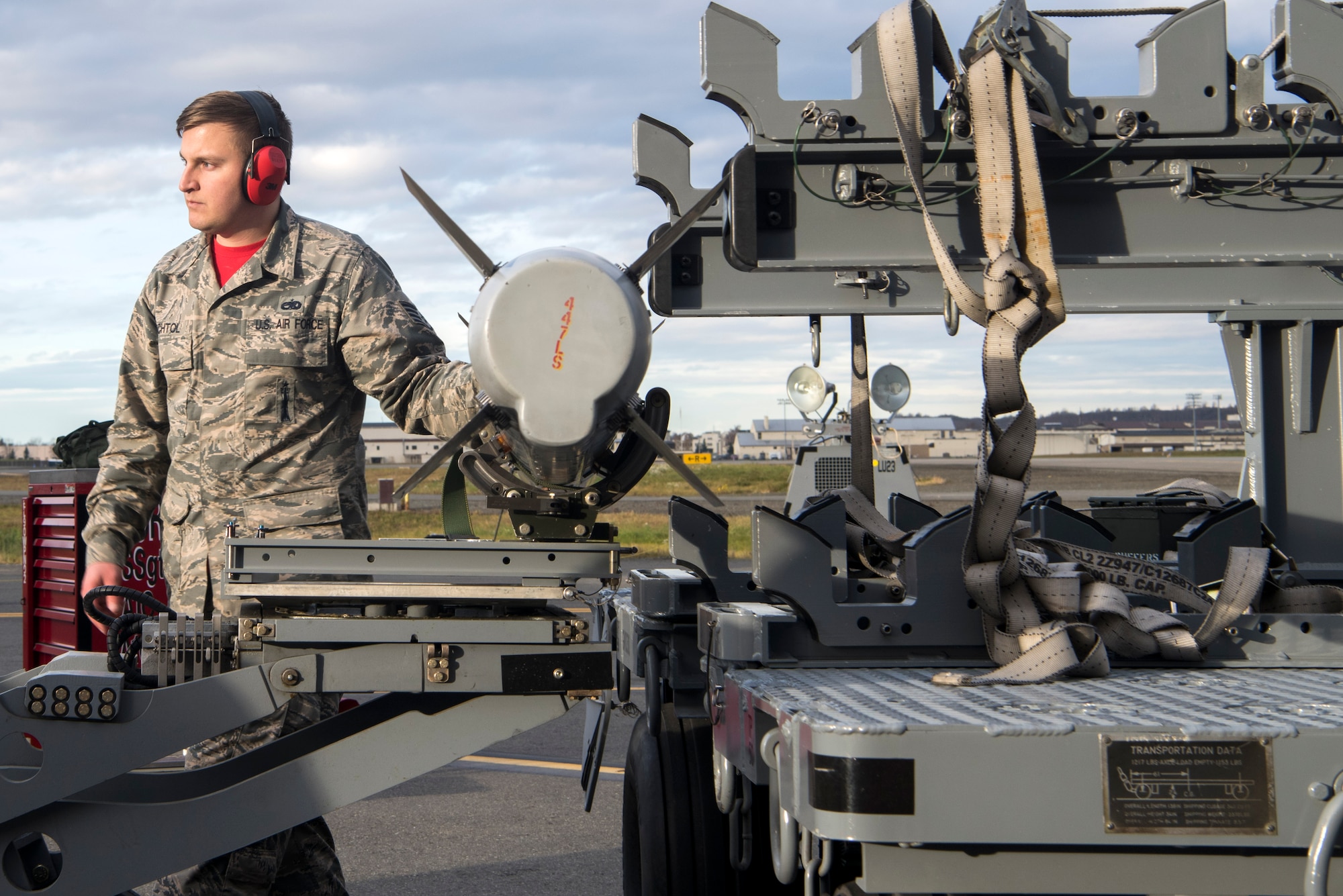 U.S. Air Force Staff Sgt. Taylor Bechtol, a 90th Aircraft Maintenance Unit weapons load crew chief, helps prepare the munition to be lifted by the jammer during the quarterly load competition at Joint Base Elmendorf-Richardson, Alaska, Oct. 26, 2018. During the competition, two teams tested their skills as load crew members for the F-22 Raptor. The event demonstrates the skill level and knowledge of all JBER aircraft maintainers.
