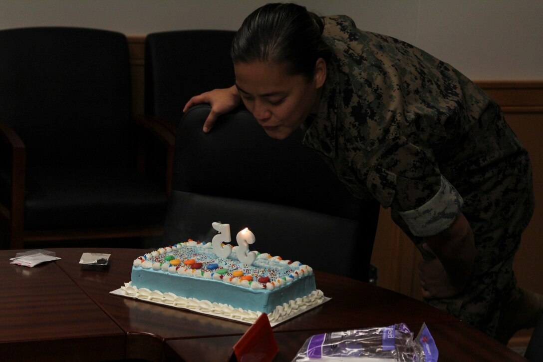 Gunnery Sgt. Tiffany A. Freeman, U.S. Marine Corps Forces Korea personnel chief, blows out candles during the command’s celebration of her birthday, here.  The Marines of MARFORK G-1 surprised Freeman with the birthday cake and the recognition of the entire staff. (Official U.S. Marine Corps photo by Sgt. Nathaniel Hanscom/ Released)