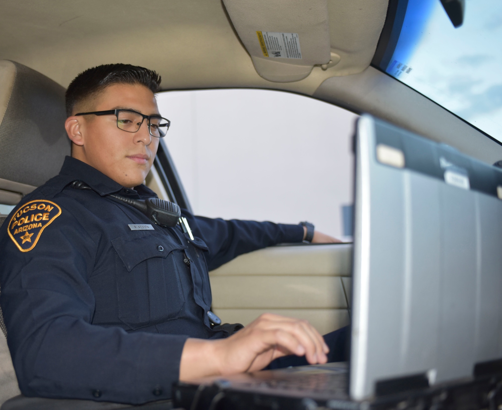 Air Force Staff Sgt. Rodrigo Acosta, a security forces specialist with the Arizona Air National Guard's 162nd Wing and a Tucson Police Department police officer, reviews data on his patrol car laptop in Tucson, Arizona, Aug. 28, 2018. Acosta said he thrives in settings outside of the office environment. "I can't see myself sitting behind a desk at all. I think I would fall asleep," he said. "Law enforcement and security forces always keeps me on my toes."