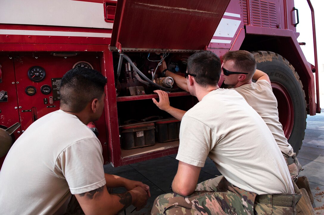Air Force firefighters receive instructions using the water valves on the P-19B fire truck.
