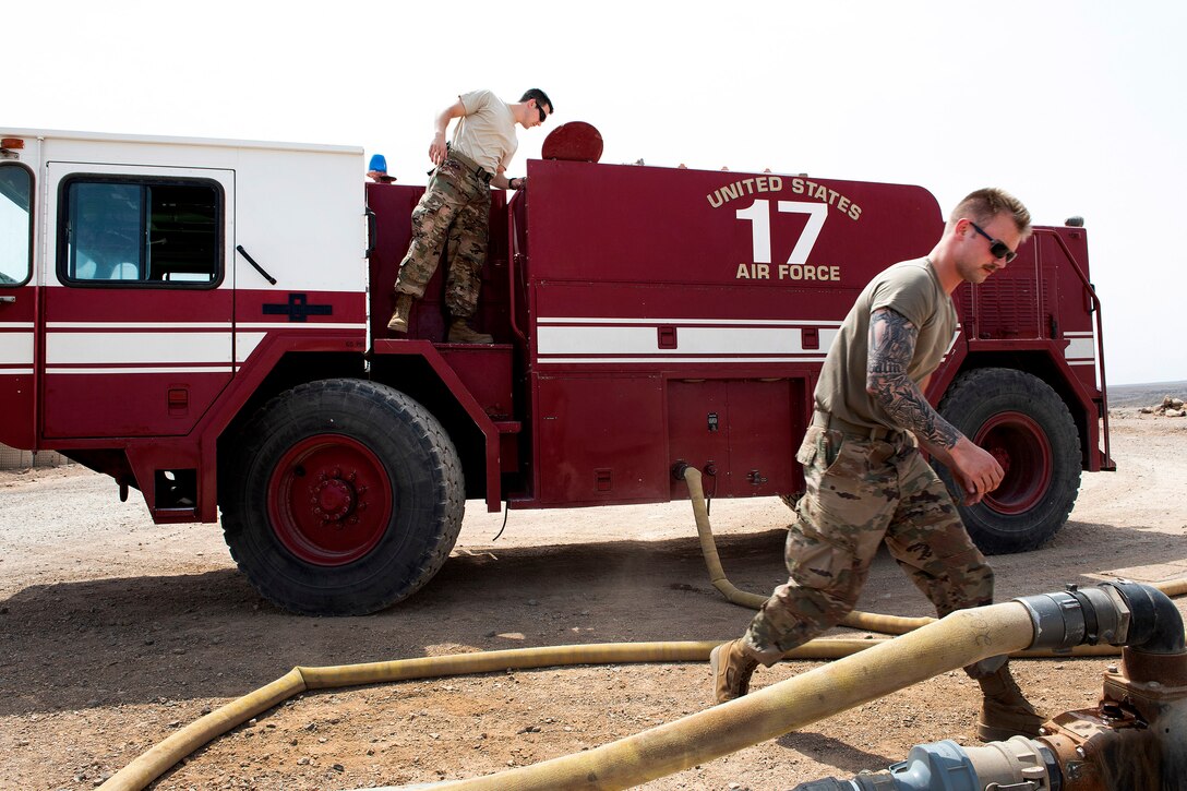 Air Force firefighters fill the water tank on a P-19B fire truck.
