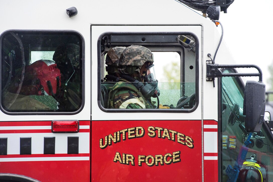 Airmen sit in a fire truck.