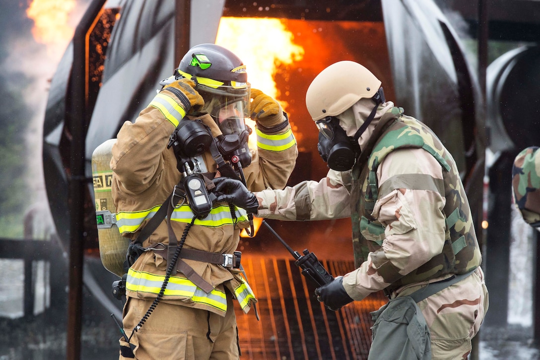 An Air Force firefighter receives a safety inspection.
