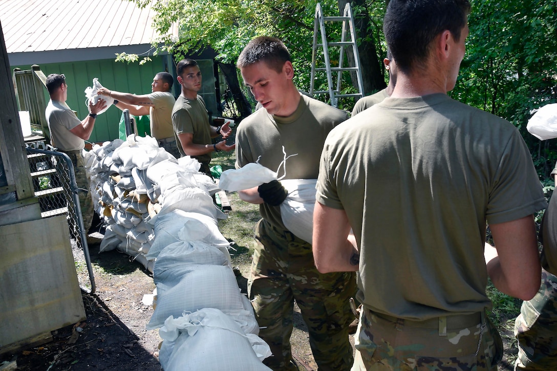 Soldiers build a sandbag retaining wall.