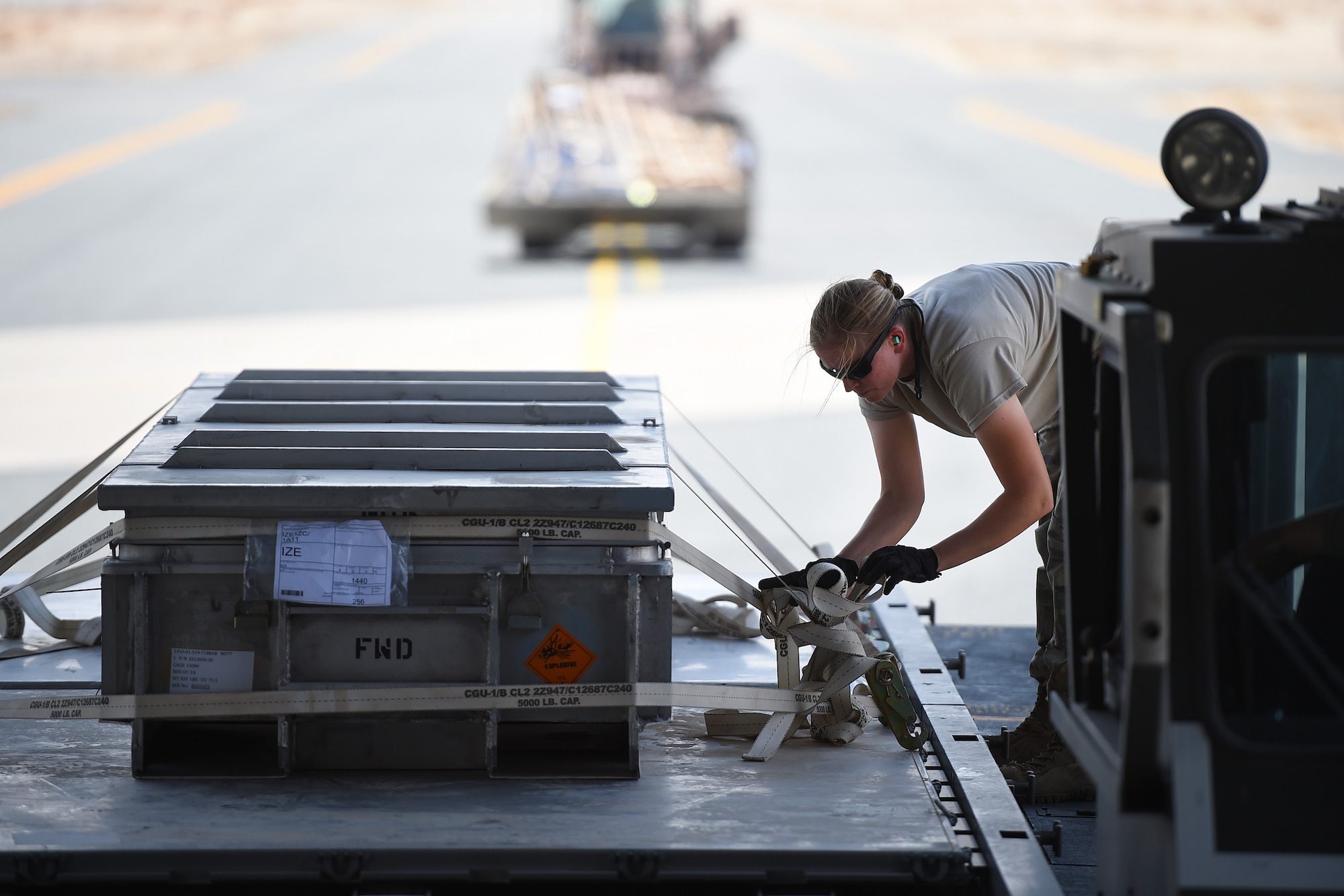 Airmen push cargo in the back of a C-17.