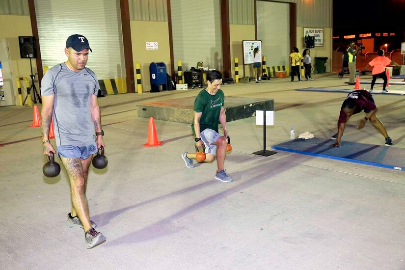 U.S. Army Sgt. 1st Class Joe Perez (left) and Command Sgt. Maj. Jennifer Redding of 1st Medical Brigade lunge at a station at the Sisters in Arms circuit training event at Camp As-Sayliyah, Qatar, August 23, 2018.  Leaders were engaged and encouraging participants throughout the entire event.