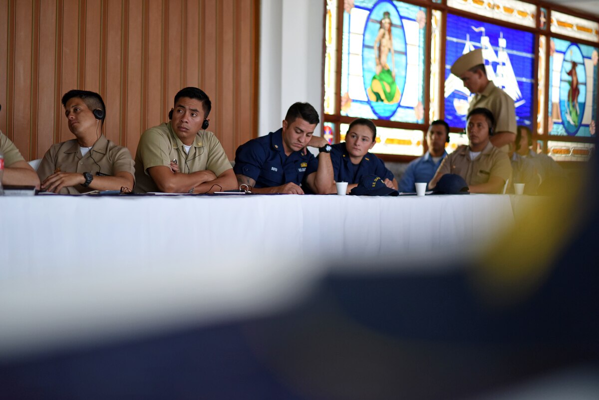 Military officials listen to a briefing