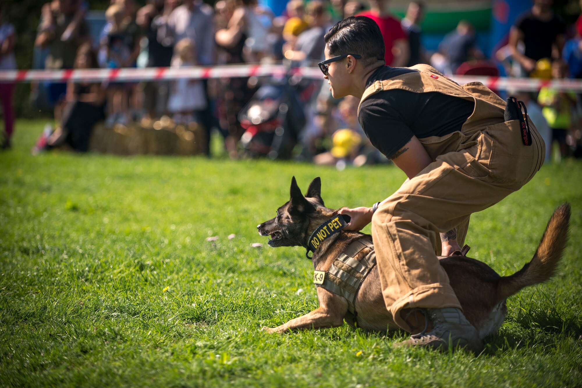 U.S. Air Force Staff Sgt. Kristina Santos, 100th Security Forces Squadron military working dog handler and MWD Ukkie, perform a MWD demonstration at the Newmarket Fire and Police Fun Day in Newmarket, England, Sept. 2, 2018. The 100th SFS MWD teams provided demonstrations at the event to showcase the abilities and obedience of the MWD teams. (U.S. Air Force photo by Staff Sgt. Christine Groening)