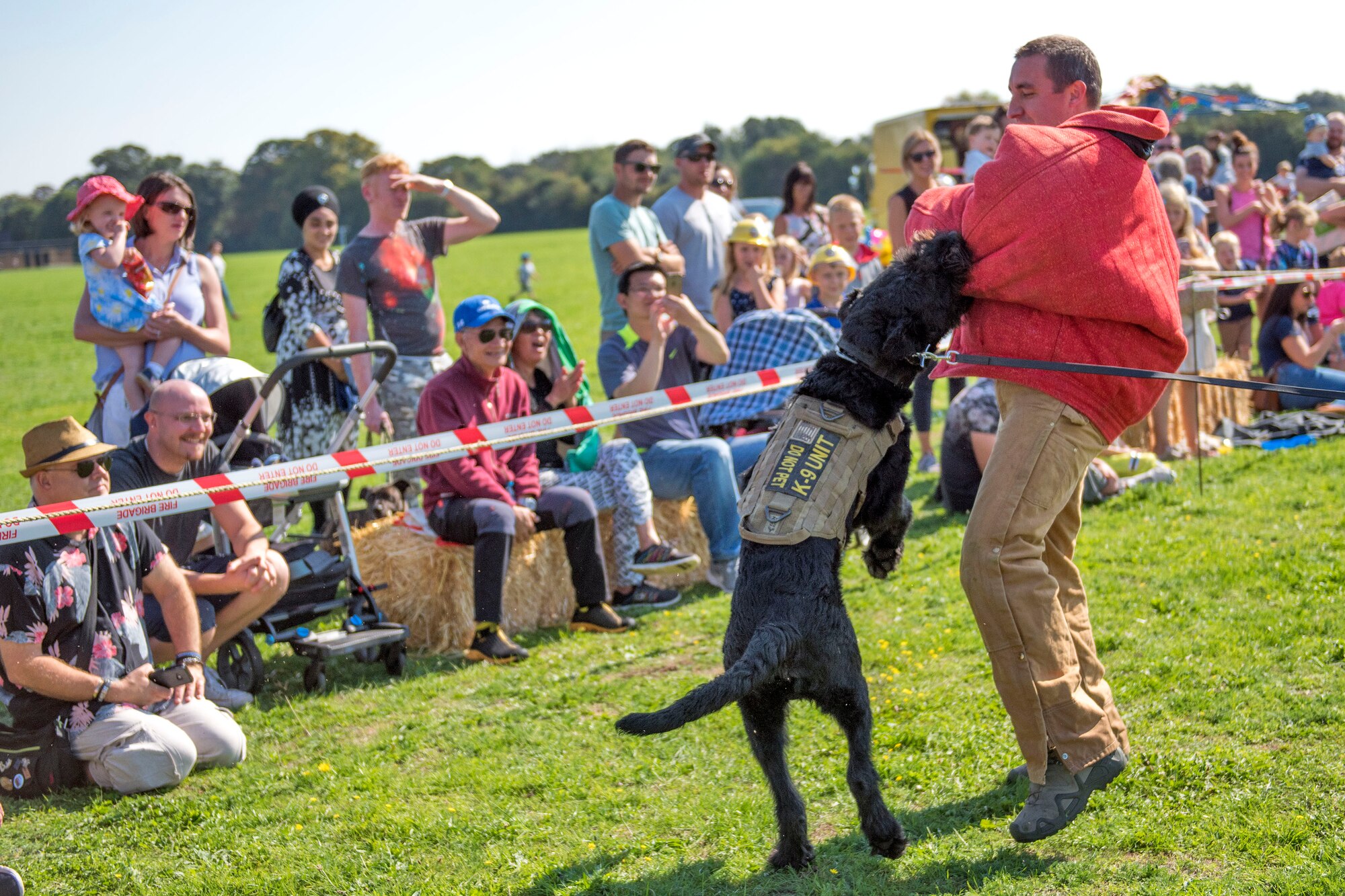 U.S. Air Force Tech. Sgt. Kelly Webster, 100th Security Force Squadron military working dog handler, MWD Brock perform a demonstration during the Newmarket Fire and Police Fun Day in Newmarket, England, Sept. 2, 2018. The MWD teams conduct demonstration for the public to educate them on what they provide to the 100th Air Refueling Wing mission. (U.S. Air Force photo by Staff Sgt. Christine Groening)