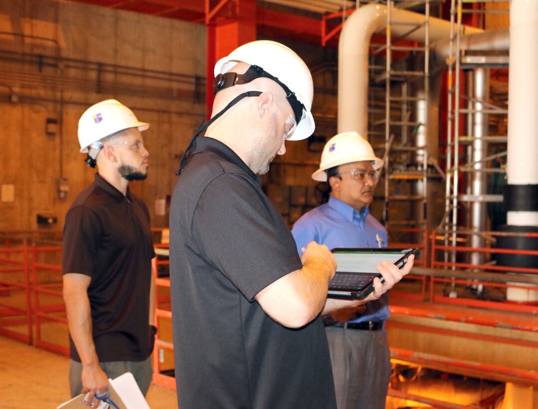 A representative with NORESCO, a Super Energy Savings Performance contractor, walks through one of the facilities at Arnold Air Force Base to look at lighting and other areas where energy savings might occur. NORESCO recently received a $19.7 million energy savings performance contract award to perform work at Arnold through the Air Force Civil Engineering Center and Defense Logistics Agency. Pictured in back is Reggie Floyd, Energy and Utility Program Manager, and Kazi Mamun, Arnold Resource Efficiency Manager. (U.S. Air Force photo by Deidre Ortiz)