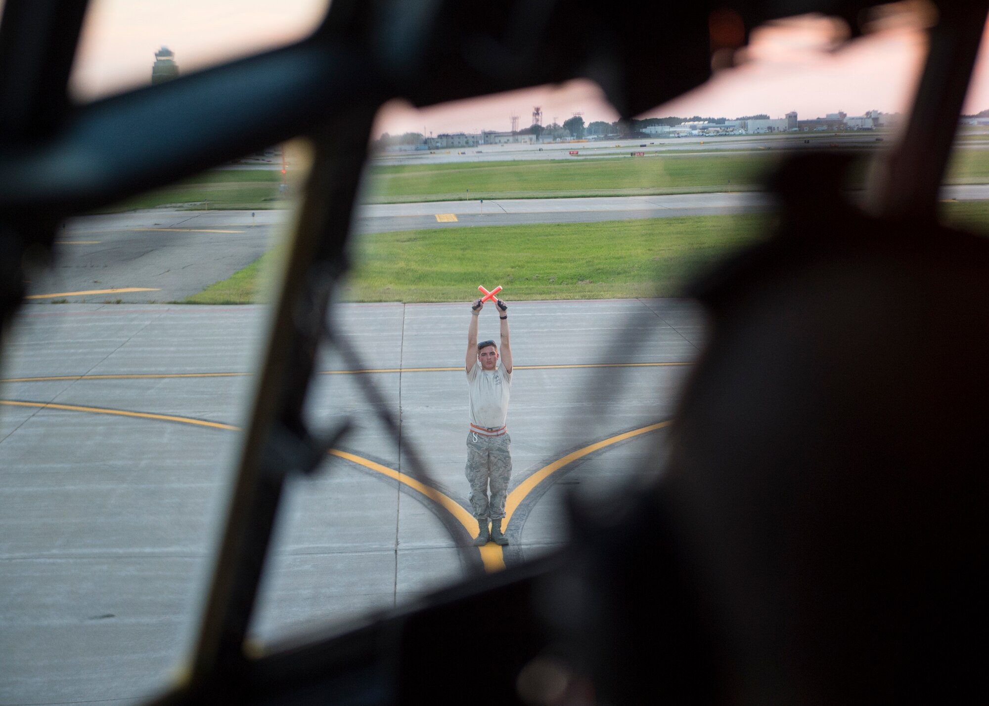 U.S. Air Force Airman 1st Class Ryan Dunlap, a crew chief with the 133rd Aircraft Maintenance Squadron, marshals a C-130 Hercules into the proper parking spot during a training in St. Paul, Minn., Aug. 8, 2018.