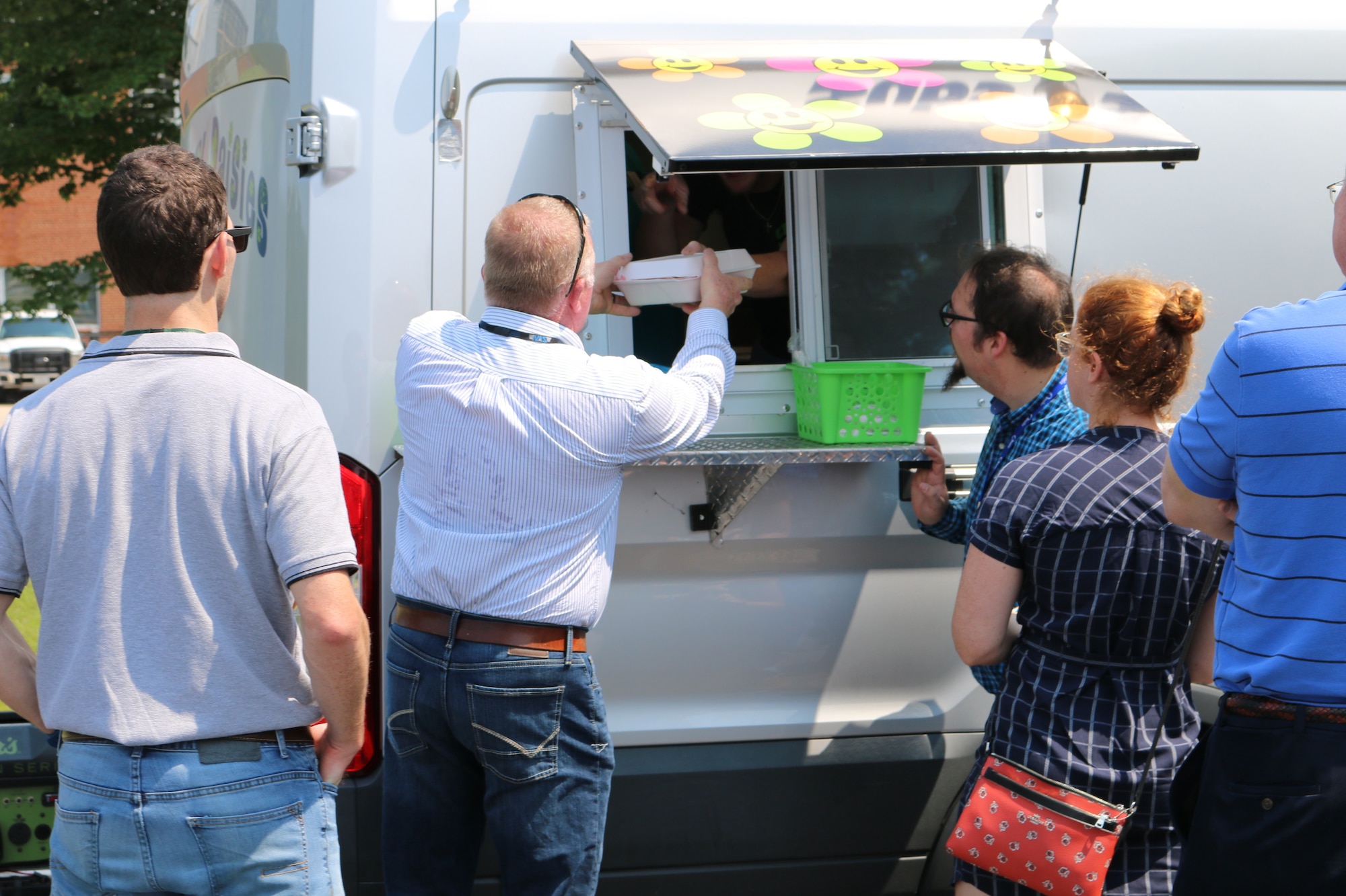 An AEDC team member receives his order from the Crazy Daisies food truck during its first day of operations at Arnold Air Force Base. The food truck, which is located in the parking lot of the Main Auditorium, began business at Arnold on Aug. 14. (U.S. Air Force photo by Bradley Hicks)