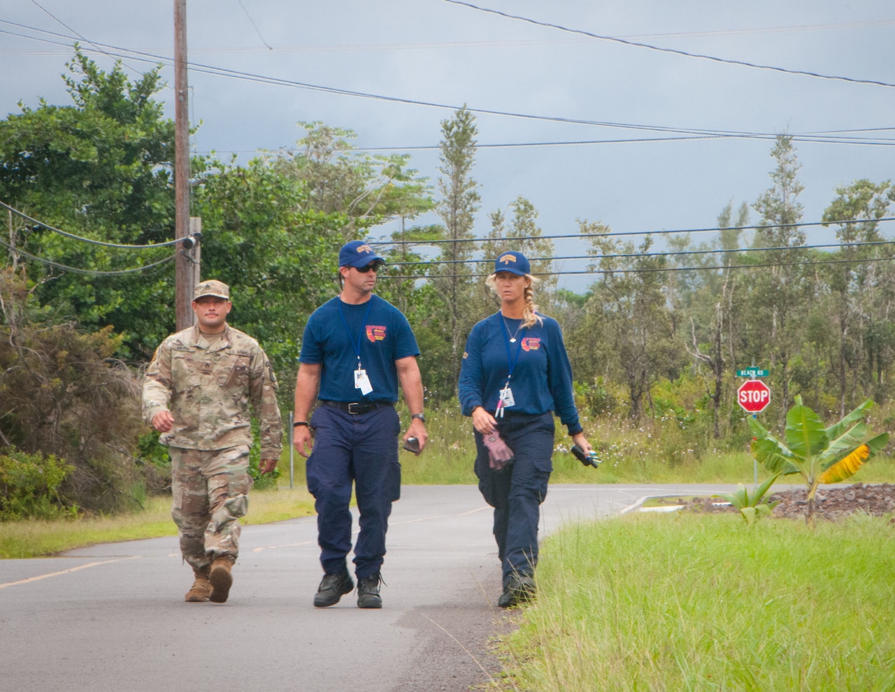 Staff Sgt. William Muira, from the Hawaii National Guard's CBRNE Enhanced Response Force Package (CERFP) Team, escorts FEMA Urban Search and Rescue members from California Task Force 3 while they perform a wide-area assessment in the wake of Hurricane Lane in Kea'au, Hawaii, on Aug. 27, 2018.
