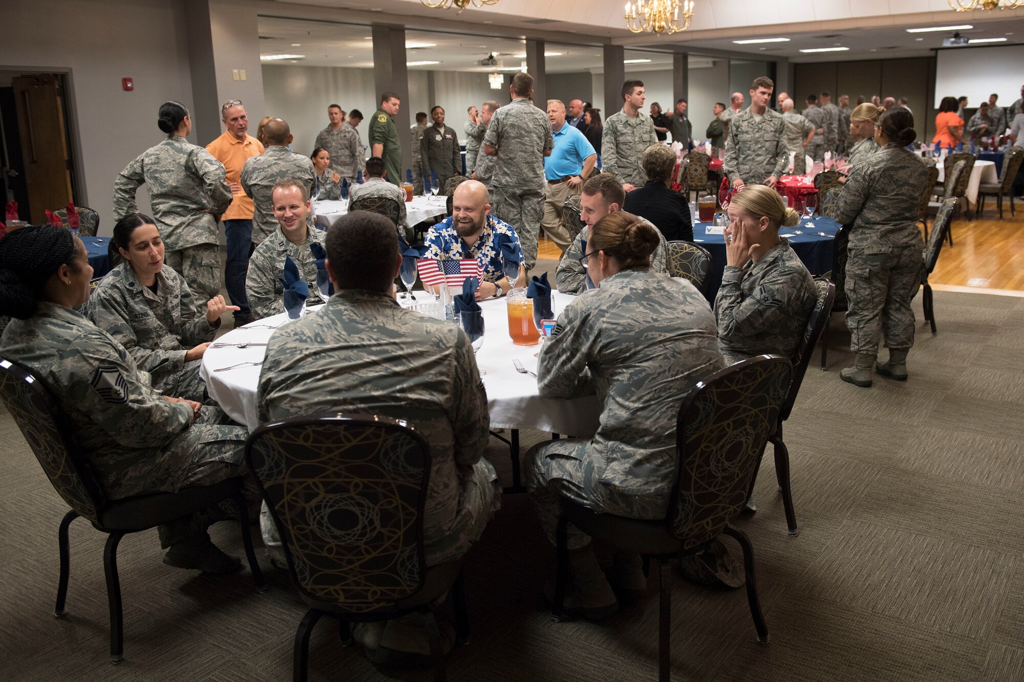 Men and women converse in a large room.