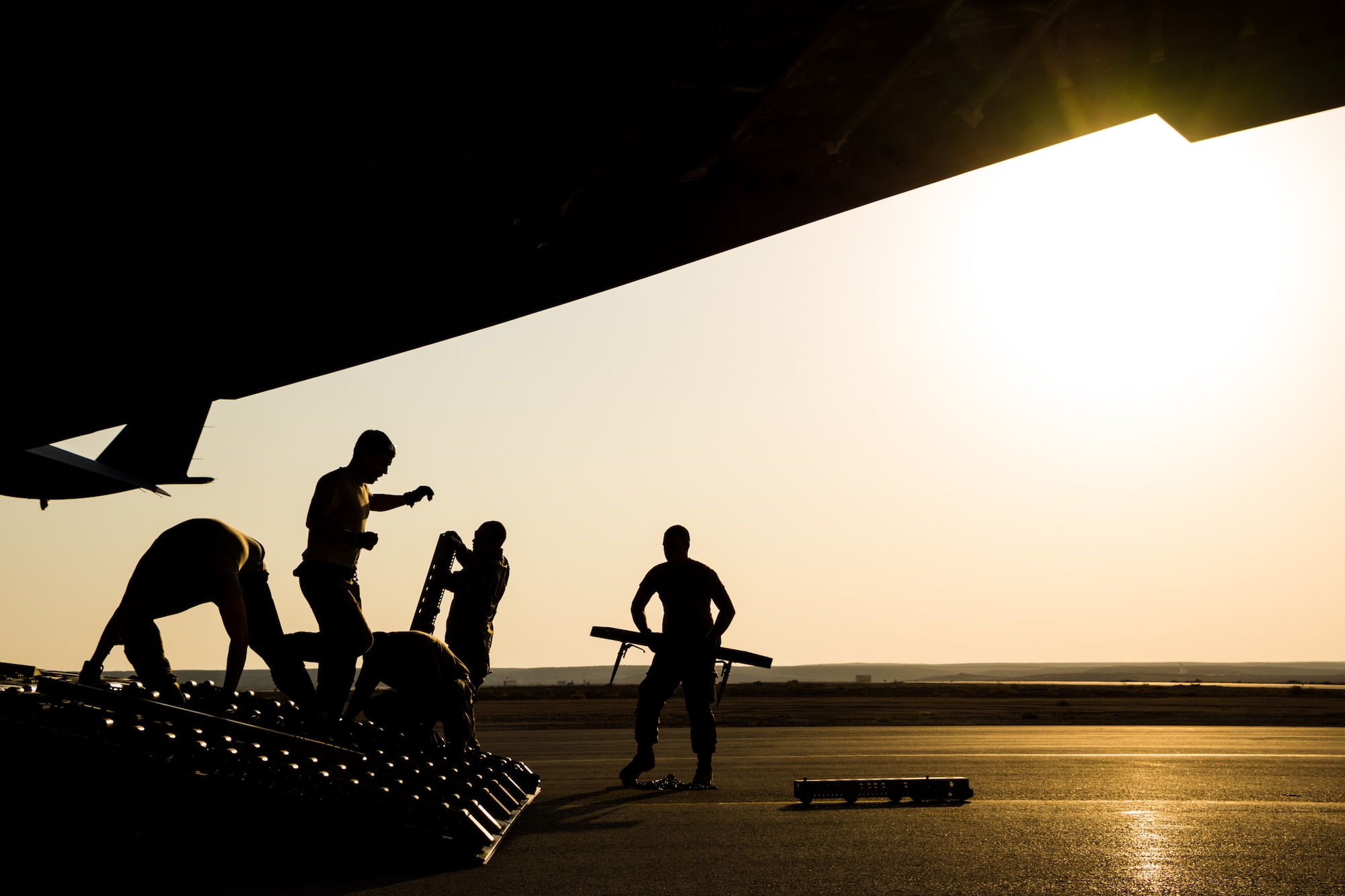Personnel from the 816th Expeditionary Airlift Squadron and 332nd Air Expeditionary Wing prepare to load cargo on a C-17 Globemaster III at an undisclosed location in Southwest Asia after transporting cargo between U.S. Africa Command and U.S. Central Command, Aug. 28, 2018. Al Udeid-based aircraft have completed nearly 15 missions this calendar year between the two commands. (U.S. Air Force photo by Tech. Sgt. Ted Nichols/Released)