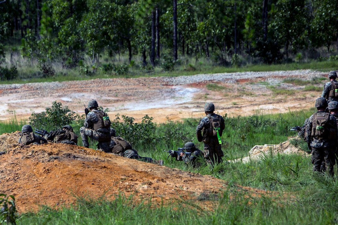 Marines fire rifiles toward a target during a deployment training exercise.