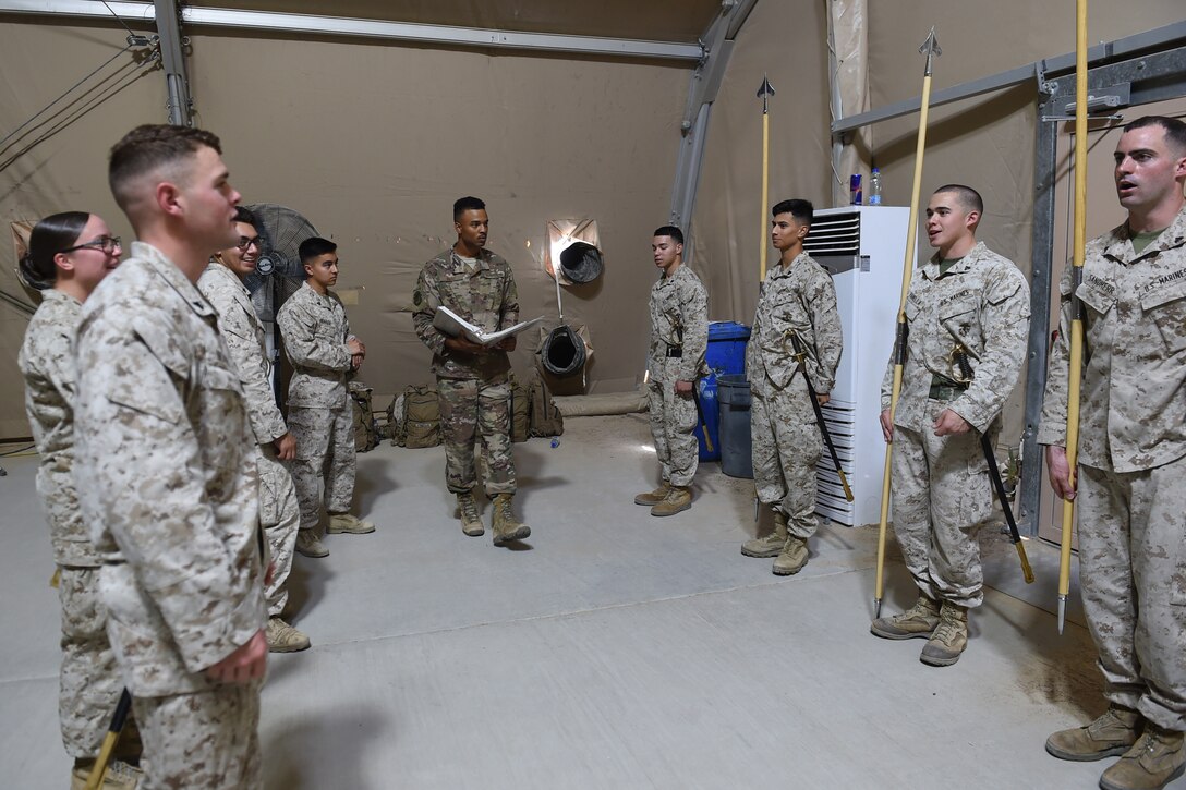 An Airman stands next to a group of Marines