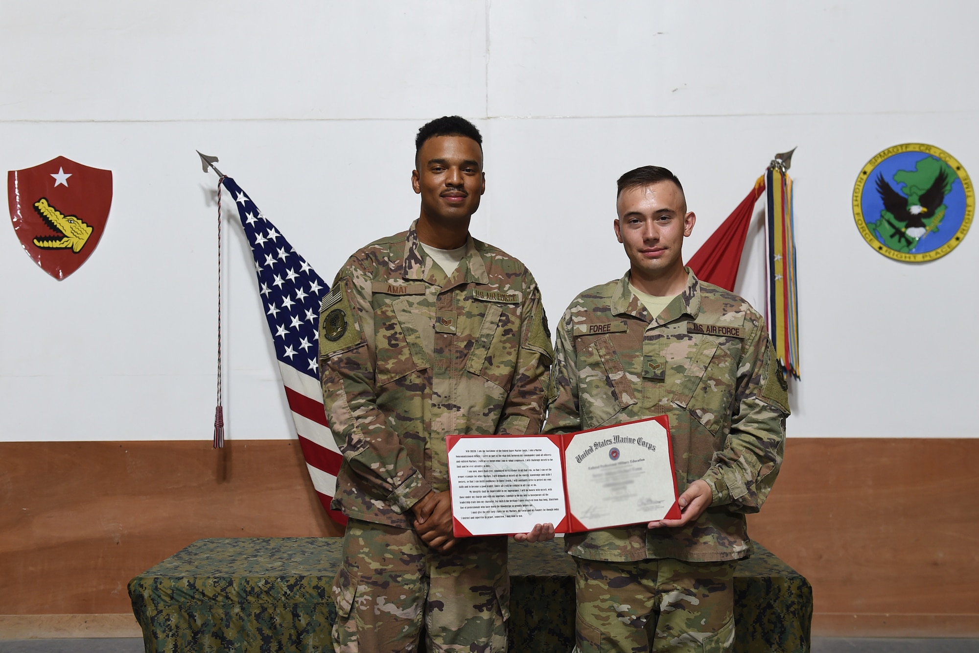 Two Airmen pose for a photo with a certificate