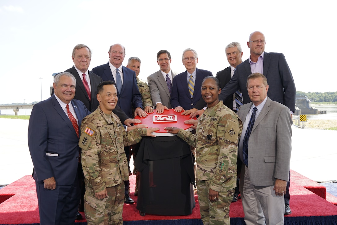 A group of distinguished guests gathers to push the ceremonial Corps button to perform the simultaneous ribbon-cutting and first lockage through the Olmsted Locks and Dam