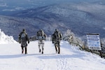 Soldiers hiking down Jay Peak, Vermont in snow.