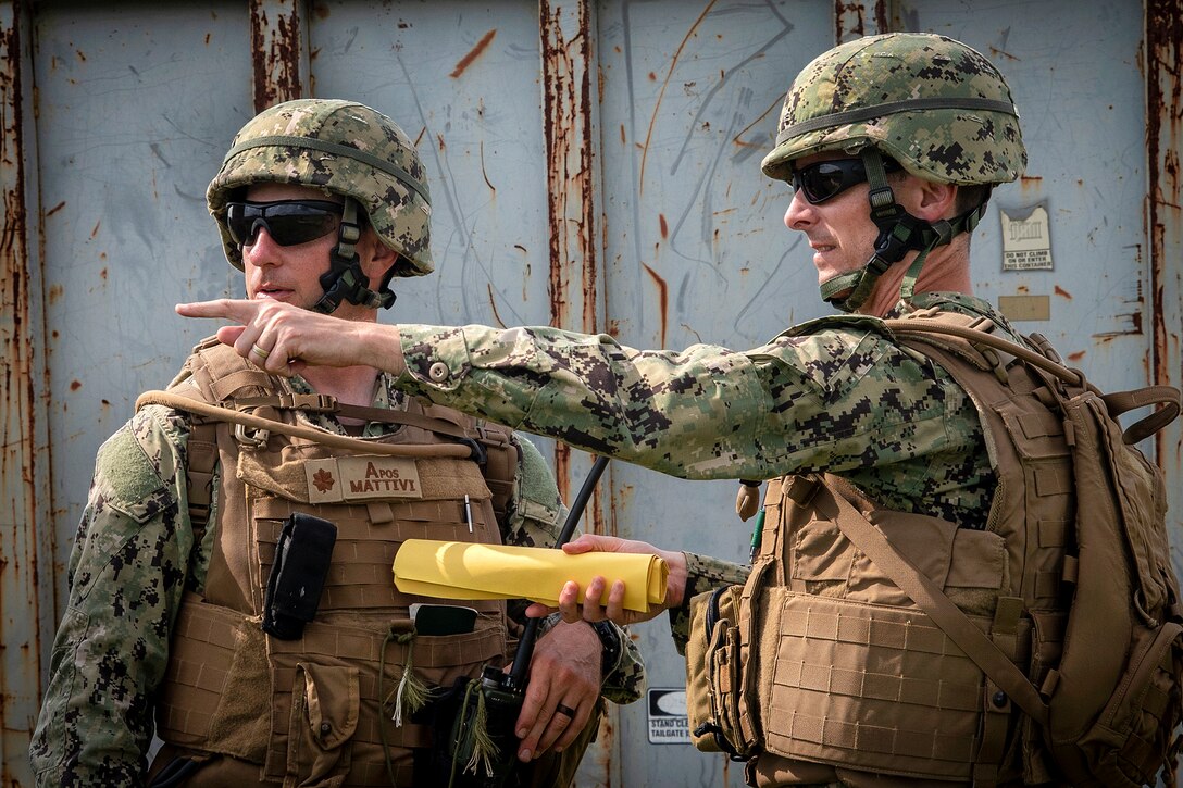Sailors discuss tactical operations during a field training exercise.